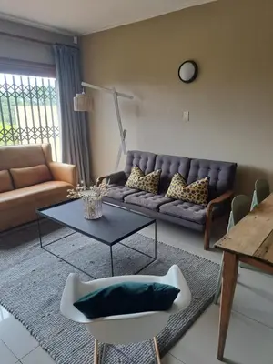 a living room with a couch and a table at Pearlmar Views in Cape Town