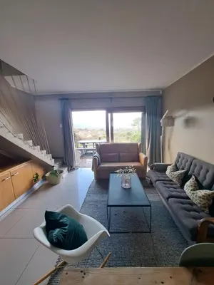 a living room with a couch and a table at Pearlmar Views in Cape Town