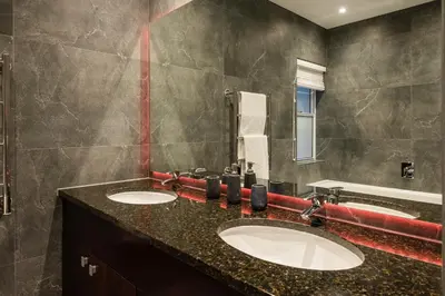a bathroom with two sinks and a mirror at Serviced Beach Penthouse, 100k Gemstone display, All Ensuite in Cape Town