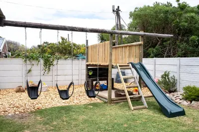 a playground with a swing and a slide at La Haven Self Catering in Hermanus