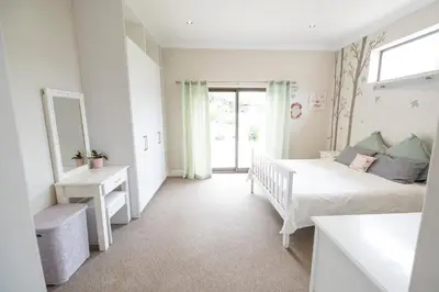 a bedroom with a bed and a mirror at La Haven Self Catering in Hermanus