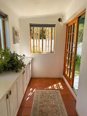 a kitchen with a window and a tiled floor at Arkelshoek Cottages in Stellenbosch