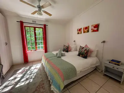 a bedroom with a bed and a window at Arkelshoek Cottages in Stellenbosch