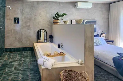 a bedroom with a bath tub next to a bed at House of Anjel in Suider-Paarl