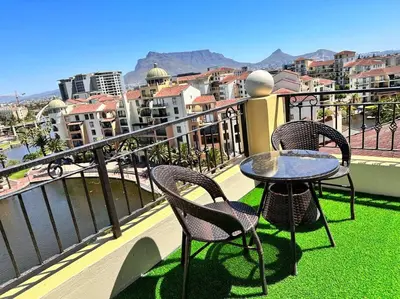 a table and two chairs on a balcony with a view at 30% off Designer Penthouse - backup power - Cape Town in Cape Town