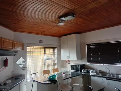 a kitchen with white cabinets and a wooden ceiling at Cape Town 5 bedroom house Belhar in Cape Town