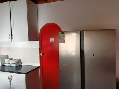 a kitchen with a red door next to two refrigerators at Cape Town 5 bedroom house Belhar in Cape Town