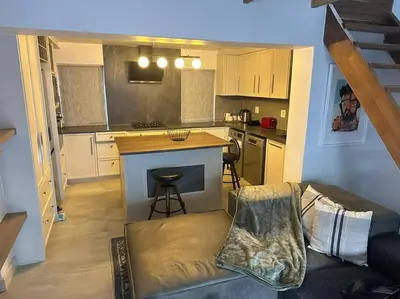 a kitchen with a couch and a counter in a room at Lemon House Modern duplex by UCT in Cape Town