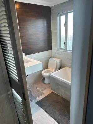 a bathroom with a toilet and a tub and a sink at Lemon House Modern duplex by UCT in Cape Town