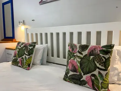 a bed with two pillows on top of it at Sunset Starfish Apartment in Cape Town