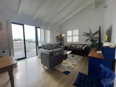 a living room with a couch and chairs and a table at Sunset Starfish Apartment in Cape Town