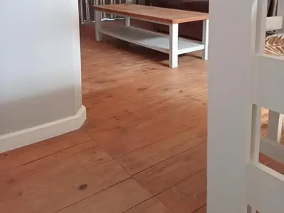 a room with a table and a wooden floor at Gizelle in Cape Town