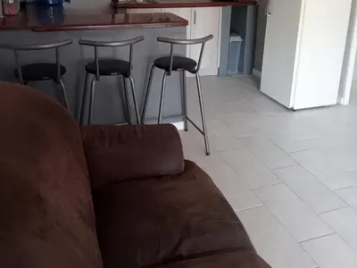 a living room with a couch and some bar stools at Gizelle in Cape Town