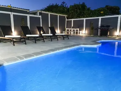a swimming pool with chairs and a picnic table next to it at Howards Villas in Cape Town