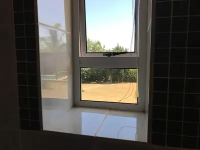 a window in a bathroom with a view of a yard at Tolbos Garden in Cape Town