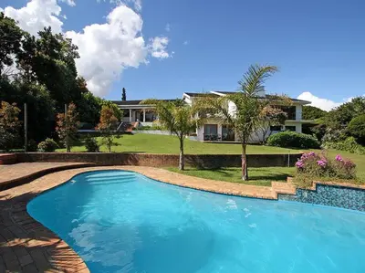 a swimming pool in front of a house at Tolbos Garden in Cape Town