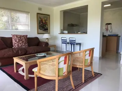 a living room with a couch and a table and chairs at Tolbos Garden in Cape Town