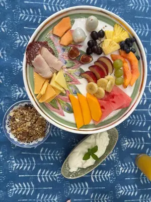 a plate of food with fruits and vegetables on a table at In the Vine Country Manor Guesthouse in Stellenbosch