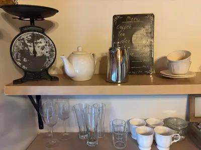 a shelf with glasses and a clock and a chalkboard at In the Vine Country Manor Guesthouse in Stellenbosch