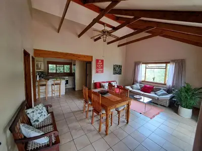 a large living room with a table and chairs at Helderberg Cottage in Somerset West