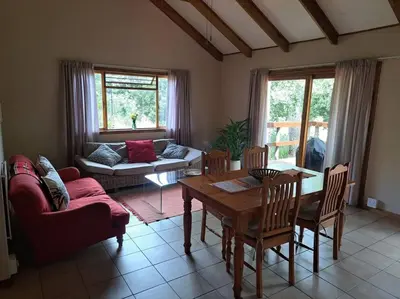 a living room with a table and a couch at Helderberg Cottage in Somerset West