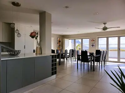a kitchen and dining room with a table and chairs at 'Antilles'- 6 Bedroom Luxury Villa On The Beach, Sleeps 12 in Gordonʼs Bay
