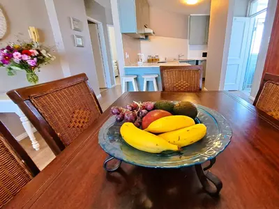 a plate of bananas and other fruits on a table at Cap d Azur beachfront apartment in Strand
