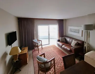 a living room with a couch and a table at Cap d Azur beachfront apartment in Strand