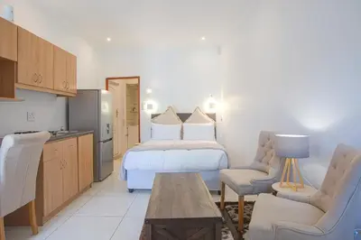 a hotel room with a bed and a kitchen at Suikerbos Guesthouse in Cape Town