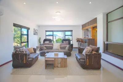 a living room with couches and a flat screen tv at Suikerbos Guesthouse in Cape Town