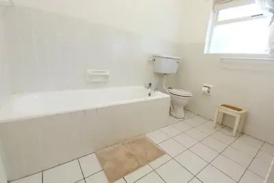 a white bathroom with a tub and a toilet at Shonalanga (The setting sun) in Hermanus