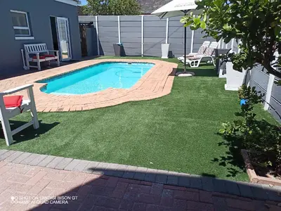 a small swimming pool in a yard with a lawn at Stay Palm 2 in Cape Town