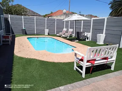 a small swimming pool in a yard with a bench at Stay Palm 2 in Cape Town