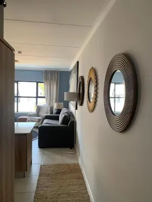 a living room with a couch and a mirror at Luxury Beach Apartment in Cape Town