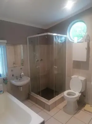 a bathroom with a shower and a toilet and a sink at Calmness in Claremont in Cape Town