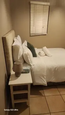 a child laying on a bed next to a table at Calmness in Claremont in Cape Town