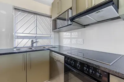 a kitchen with a sink and a stove at Sea Spray B306 in Bloubergstrand