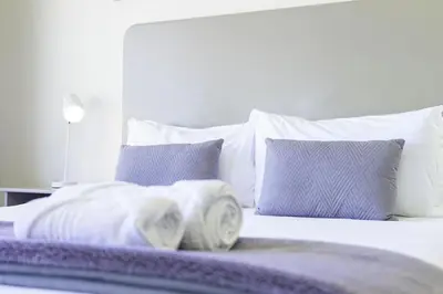 a bed with towels on it with pillows at Sea Spray B306 in Bloubergstrand