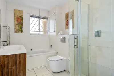 a bathroom with a toilet and a sink and a shower at Sea Spray B306 in Bloubergstrand