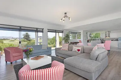 a living room with a couch and chairs and a table at Sunset Westchester Villa in Cape Town