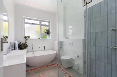 a bathroom with a tub and a sink and a toilet at Sunset Westchester Villa in Cape Town