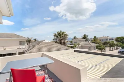 a balcony with a desk and two chairs at Sunset Westchester Villa in Cape Town