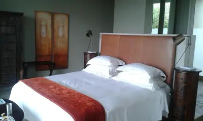 a bedroom with a large bed with a wooden headboard at Mosselberg on Grotto Beach in Hermanus
