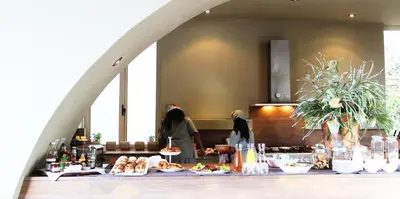 two women standing in a kitchen with food on a table at Mosselberg on Grotto Beach in Hermanus