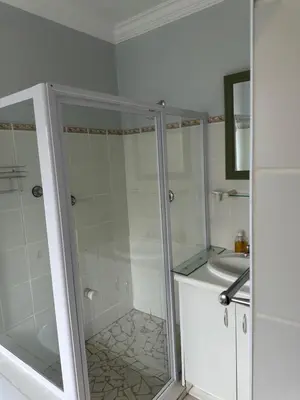 a bathroom with a shower and a sink at Tranquil Private Rooms Hermanus in Hermanus