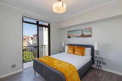 a bedroom with a bed and a large window at Resort Style Penthouse - BackUp Power in Cape Town