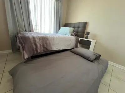 a bedroom with two beds and a window at #One6Eight in Hermanus