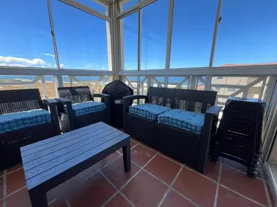 a room with chairs and a table and windows at #One6Eight in Hermanus