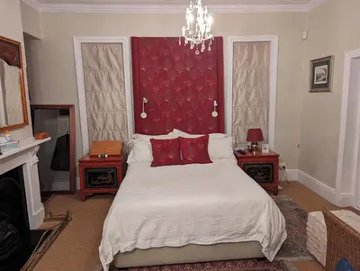 a bedroom with a large bed with a red headboard at La Montagne Observatory in Cape Town