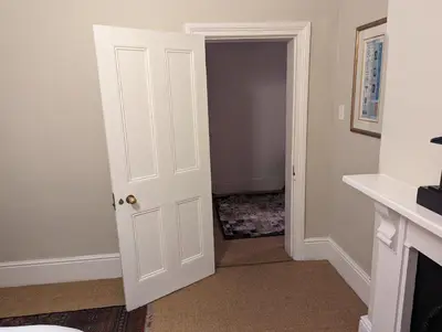 a white door leading into a room with a hallway at La Montagne Observatory in Cape Town